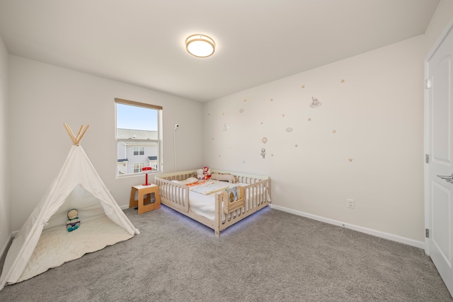carpeted bedroom with baseboards and a nursery area
