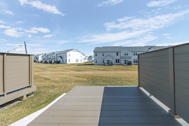 wooden deck with a residential view, an outbuilding, and a lawn