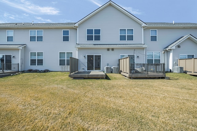 rear view of property featuring central AC unit, a lawn, and a wooden deck