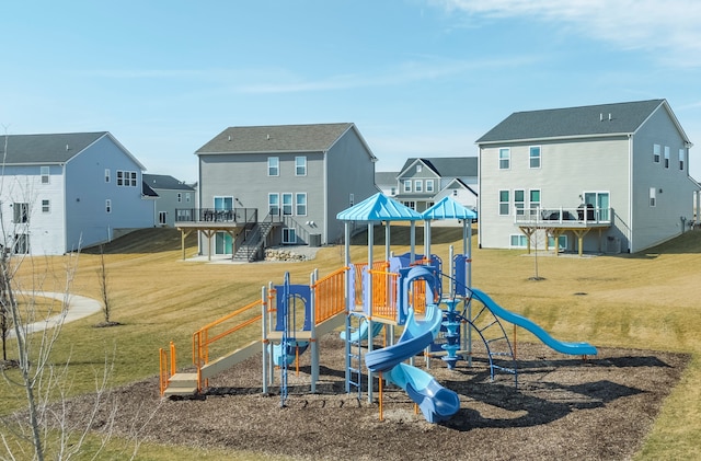 community jungle gym with a residential view, a wooden deck, and a lawn