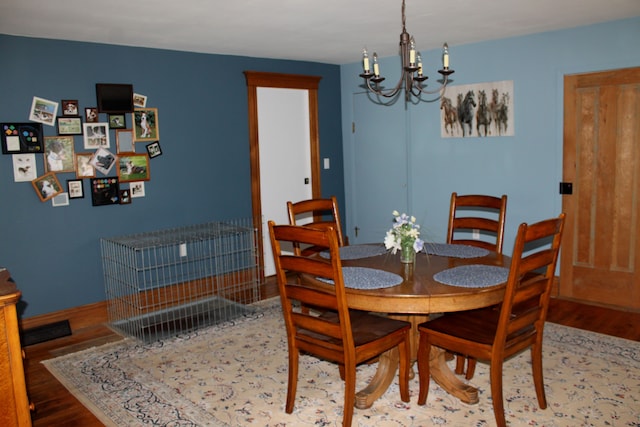 dining area featuring an inviting chandelier, baseboards, and wood finished floors