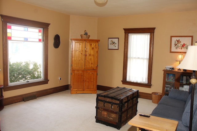 interior space with baseboards, light colored carpet, and visible vents