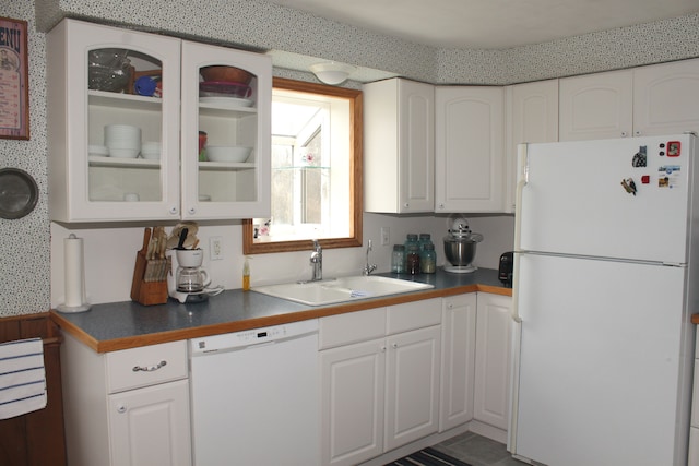 kitchen featuring a sink, glass insert cabinets, white appliances, dark countertops, and white cabinets