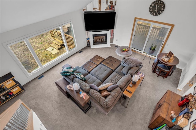 living room with visible vents, a fireplace, and carpet flooring