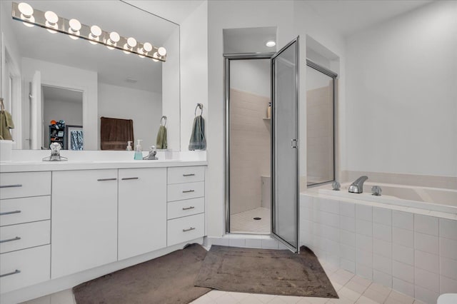bathroom with tile patterned floors, a garden tub, a stall shower, and vanity