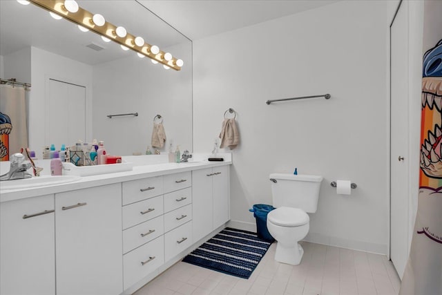 full bathroom with a sink, baseboards, toilet, and double vanity