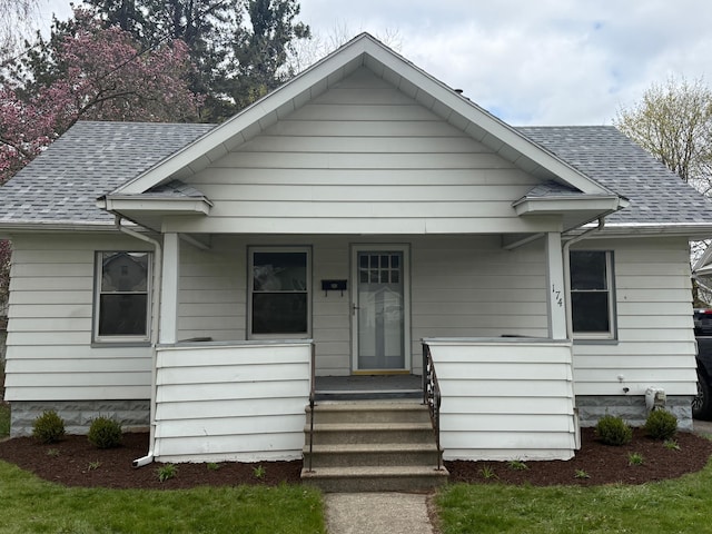 bungalow-style home with covered porch and roof with shingles