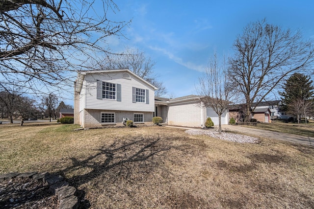 1019 Colony Dr, Saline, MI 48176 - split level home with brick siding, a front lawn, concrete driveway, and a garage