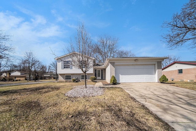 1019 Colony Dr, Saline, MI 48176 - tri-level home with concrete driveway, brick siding, a garage, and a front yard