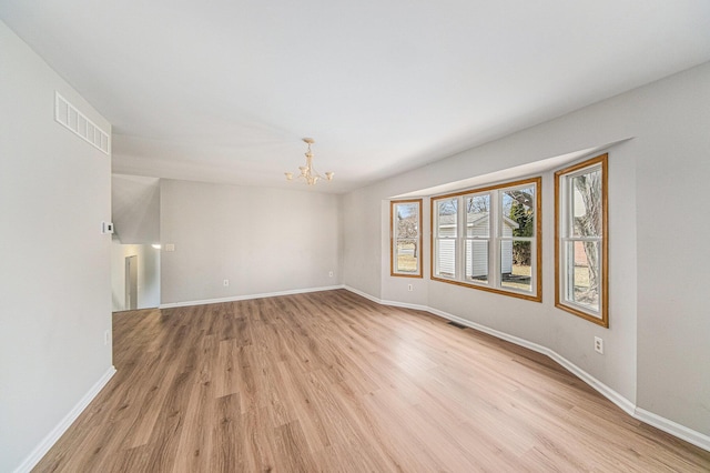 1019 Colony Dr, Saline, MI 48176 - empty room with an inviting chandelier, light wood-style flooring, baseboards, and visible vents
