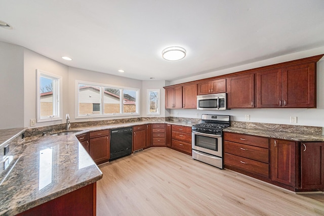1019 Colony Dr, Saline, MI 48176 - kitchen with light wood-type flooring, a sink, recessed lighting, dark stone counters, and appliances with stainless steel finishes
