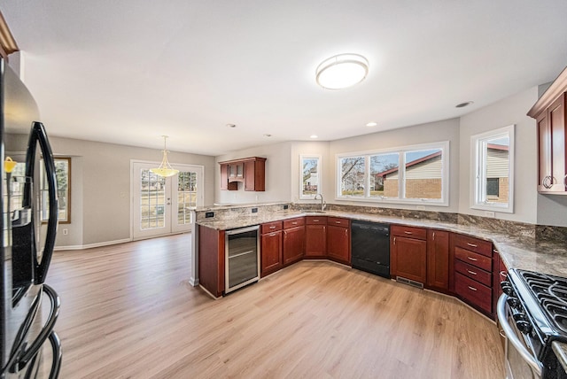 1019 Colony Dr, Saline, MI 48176 - kitchen featuring black appliances, wine cooler, a peninsula, and light wood finished floors