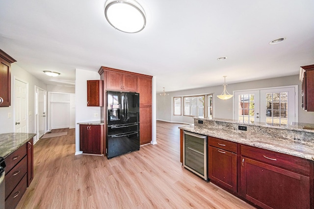 1019 Colony Dr, Saline, MI 48176 - kitchen with wine cooler, light stone countertops, light wood-type flooring, and black fridge