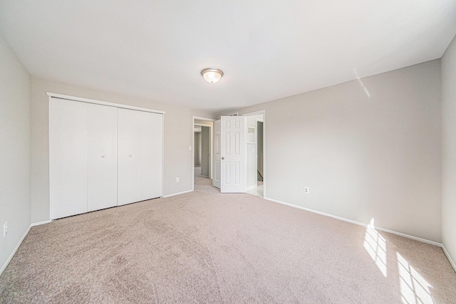 1019 Colony Dr, Saline, MI 48176 - unfurnished bedroom featuring a closet, baseboards, and light colored carpet