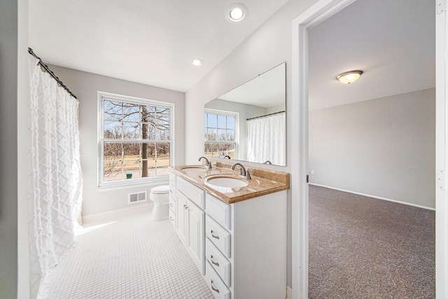1019 Colony Dr, Saline, MI 48176 - full bathroom featuring double vanity, toilet, visible vents, and a sink