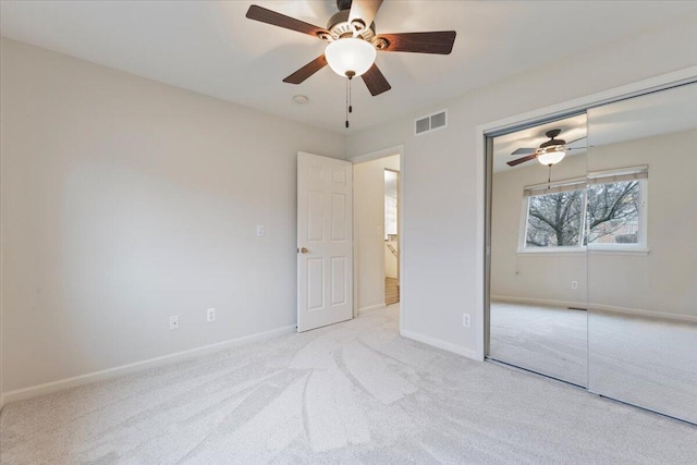 unfurnished bedroom with baseboards, visible vents, carpet floors, ceiling fan, and a closet