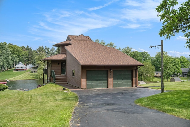 490 Skyline Dr, Horton, MI 49246 - view of front of home featuring a front yard, roof with shingles, asphalt driveway, a garage, and a water view