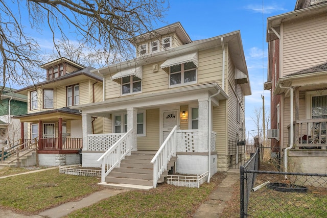 traditional style home featuring a porch, fence, and a front yard