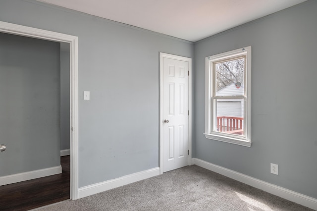 unfurnished bedroom with carpet, multiple windows, and baseboards
