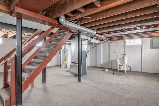 below grade area featuring electric panel, a sink, heating unit, stairs, and gas water heater