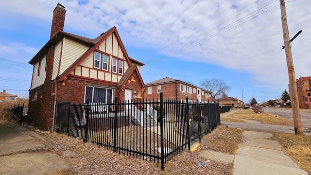 view of front of house featuring a fenced front yard, brick siding, and a chimney