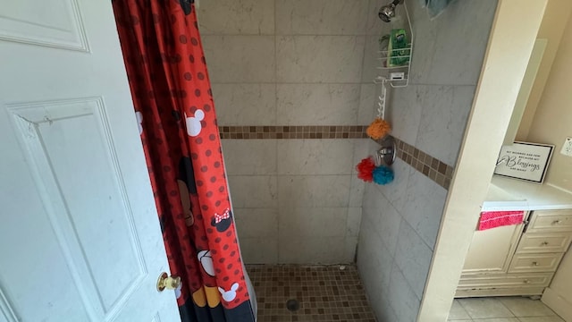 full bath with tile patterned floors and tiled shower