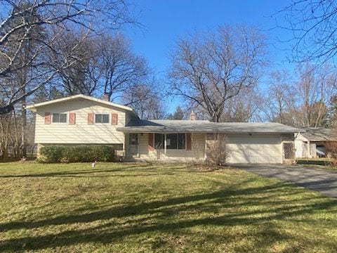 6111 Woodmoor Dr, Burton, MI 48509 - tri-level home featuring aphalt driveway, a garage, a chimney, and a front yard