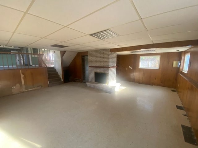 6111 Woodmoor Dr, Burton, MI 48509 - basement with stairs, a fireplace, wooden walls, and a paneled ceiling