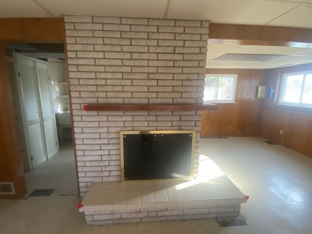 6111 Woodmoor Dr, Burton, MI 48509 - interior details with a brick fireplace, wood walls, and visible vents