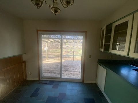 6111 Woodmoor Dr, Burton, MI 48509 - unfurnished dining area with baseboards and an inviting chandelier