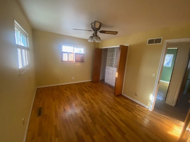 6111 Woodmoor Dr, Burton, MI 48509 - unfurnished bedroom featuring baseboards, visible vents, and wood finished floors