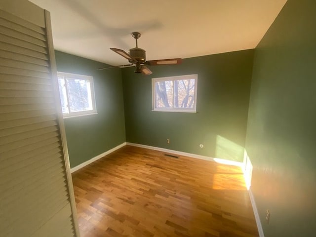 6111 Woodmoor Dr, Burton, MI 48509 - unfurnished bedroom featuring a ceiling fan, visible vents, baseboards, and wood finished floors