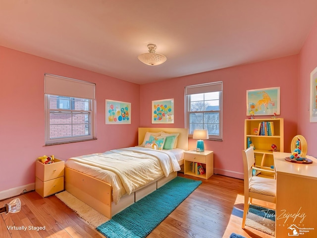bedroom with baseboards and wood finished floors