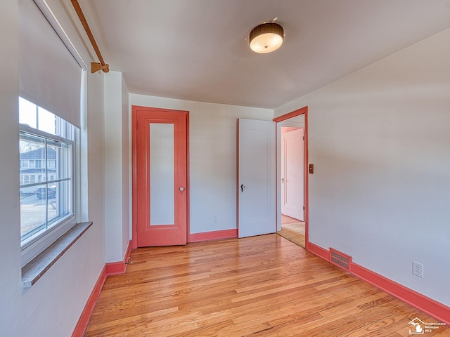 unfurnished bedroom featuring baseboards, light wood finished floors, and visible vents