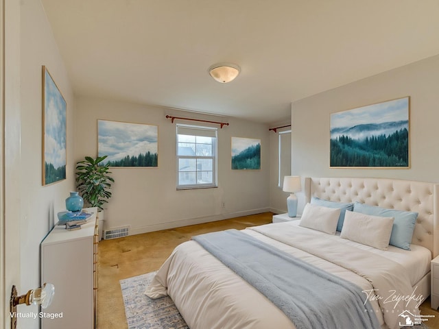 bedroom featuring light carpet, visible vents, and baseboards