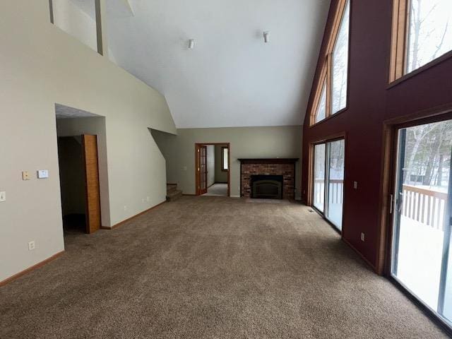unfurnished living room with baseboards, carpet floors, high vaulted ceiling, and a brick fireplace