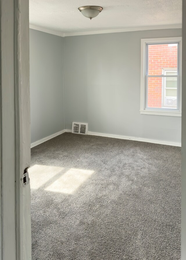 empty room featuring baseboards, a textured ceiling, visible vents, and carpet