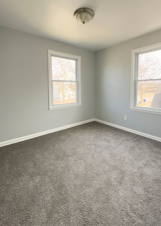 carpeted empty room with baseboards