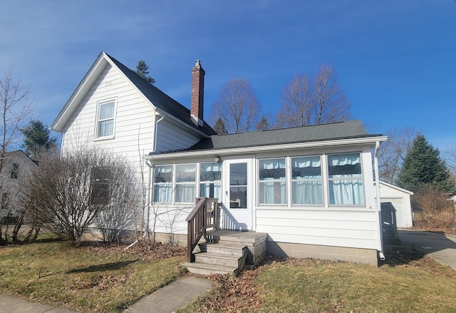 135 Handley St, Imlay City, MI 48444 - traditional-style house featuring a front yard, a sunroom, a chimney, and roof with shingles