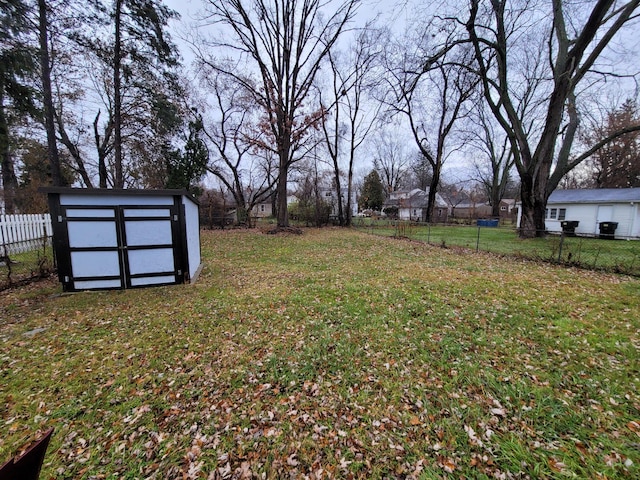 view of yard with an outbuilding, a storage unit, and a fenced backyard