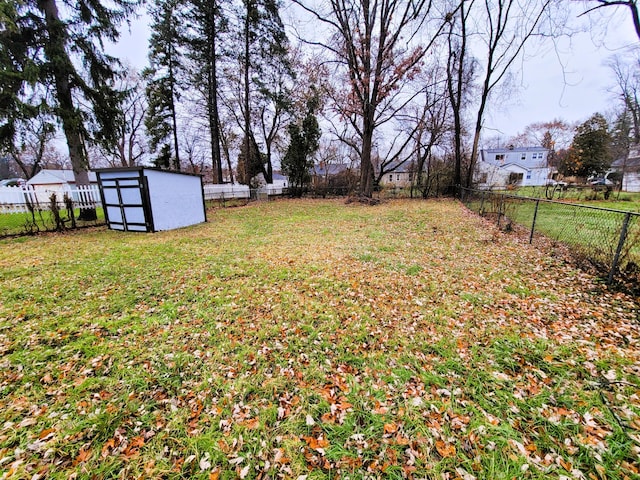 view of yard featuring a storage shed, an outbuilding, and a fenced backyard