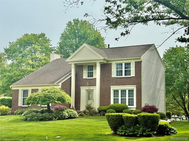 3023 Holben Dr, Lake Orion, MI 48360 - neoclassical / greek revival house with a chimney, a front yard, and brick siding