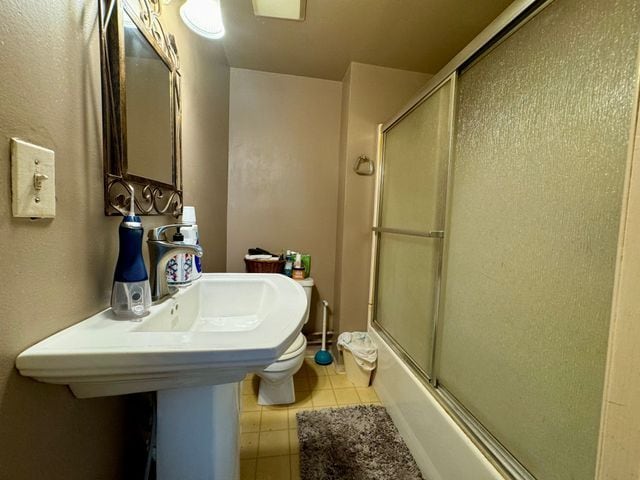 147 S Water St, Marine City, MI 48039 - bathroom with tile patterned floors, bath / shower combo with glass door, and toilet