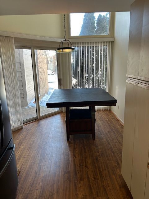 26766 Plumgrove Ln Unit 56, Farmington Hills, MI 48334 - unfurnished dining area featuring dark wood-style flooring and a healthy amount of sunlight