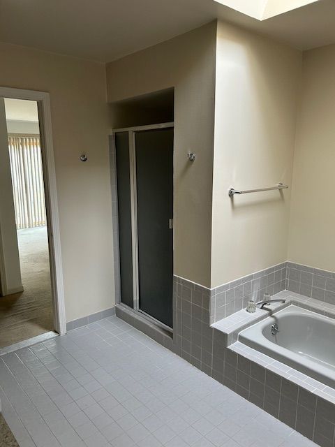 26766 Plumgrove Ln Unit 56, Farmington Hills, MI 48334 - bathroom with a shower stall, tile patterned floors, and a bath