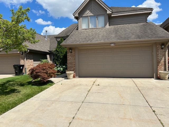 26766 Plumgrove Ln Unit 56, Farmington Hills, MI 48334 - traditional-style home featuring a shingled roof, brick siding, and concrete driveway