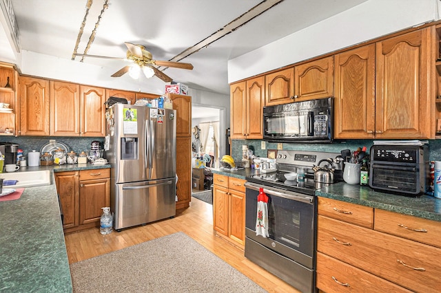 9448 Washburn Rd, Columbiaville, MI 48421 - kitchen featuring a ceiling fan, decorative backsplash, brown cabinetry, and appliances with stainless steel finishes