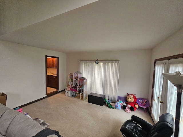 recreation room featuring light colored carpet, baseboards, and a healthy amount of sunlight