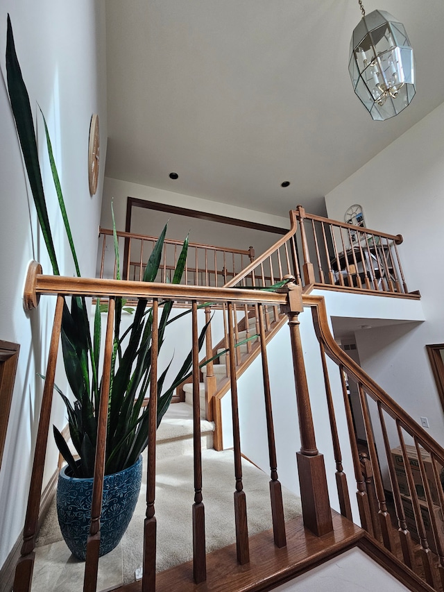 stairs with a notable chandelier