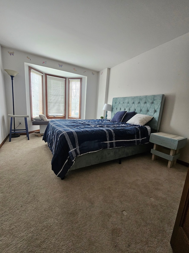 bedroom with light carpet and baseboards